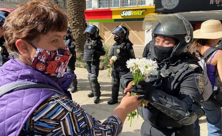 Mujeres policías reciben flores de manifestantes durante marcha
