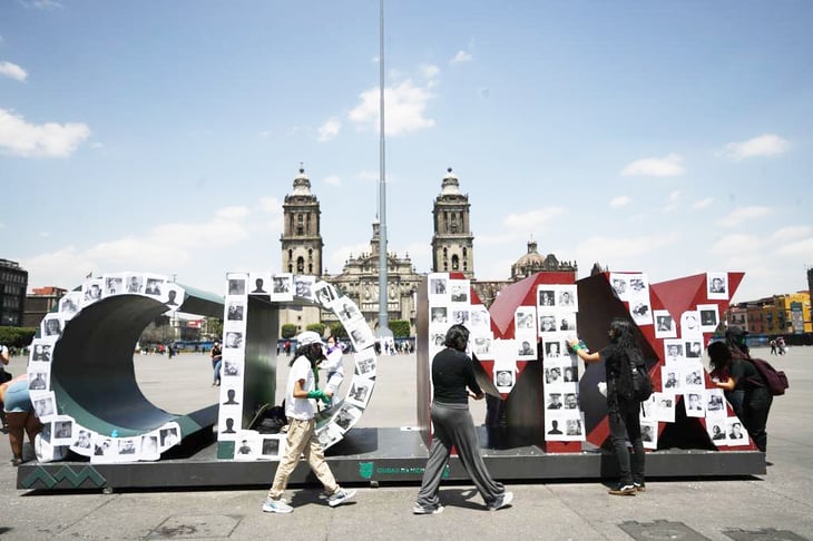 Feministas tapizan base del asta bandera del Zócalo con fotos de agresores