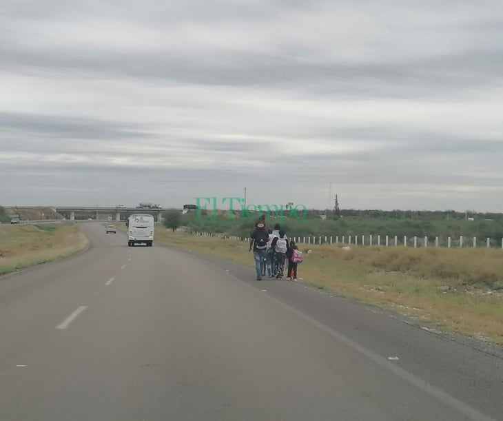 Migrantes avanzan caminando por la carretera 57