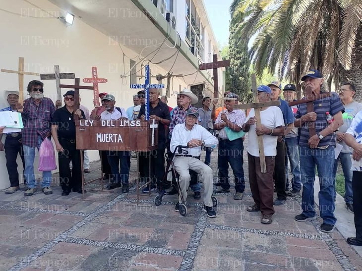 Pensionados cargan ataúd y cruces en señal de 'letra muerta' de la Ley del IMSS