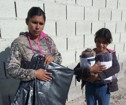 Cobertores y hules dan a familias por el frío