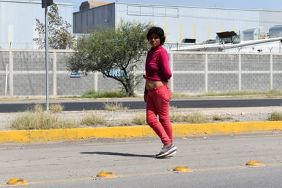 Una jovencita posa en medio del libramiento y para el tráfico 