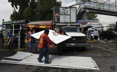 Retiran 'oficina y baño callejeros' colocados sobre puesto de ataúdes