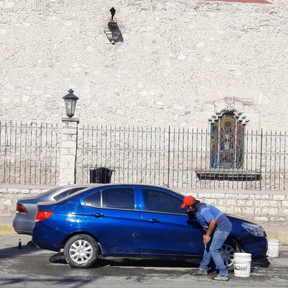 Lavacoches estacionan en doble fila a sus clientes para atenderlos