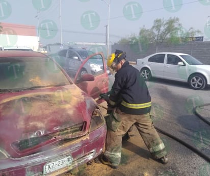 Bomberos controlan fuego en el motor de un vehículo