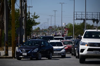 vialidad : Filas de vehículos y peatones en espera reflejan el ritmo diario del tránsito en la ciudad.