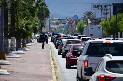 vialidad : Filas de vehículos y peatones en espera reflejan el ritmo diario del tránsito en la ciudad.