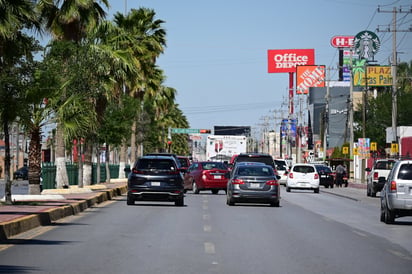 vialidad : Filas de vehículos y peatones en espera reflejan el ritmo diario del tránsito en la ciudad.