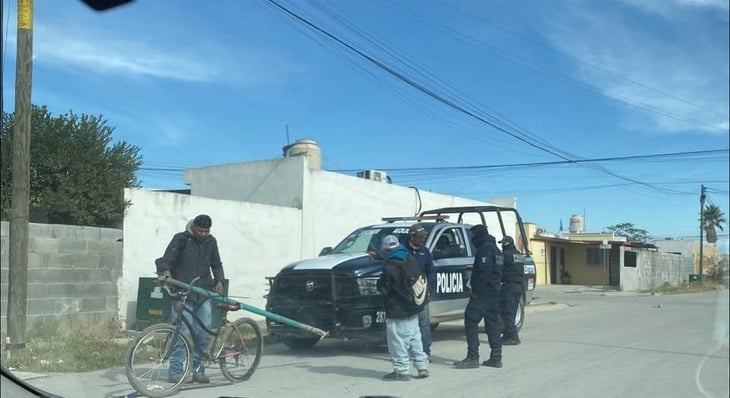 Policías de Sabinas revisan a dos ciclistas en el fraccionamiento Los Manzanos