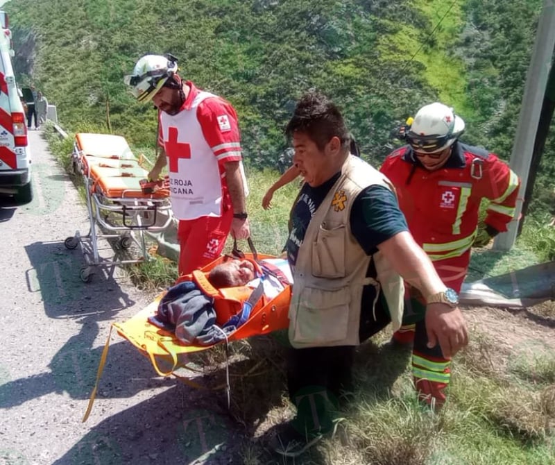 Tráiler cae de puente; socorristas tratan de ayudar al conductor.