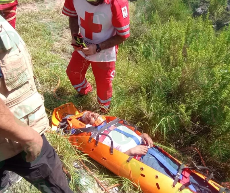 Tráiler cae de puente; socorristas tratan de ayudar al conductor.