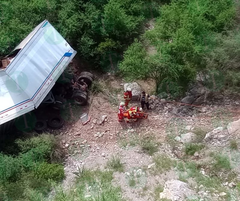 Tráiler cae de puente; socorristas tratan de ayudar al conductor.