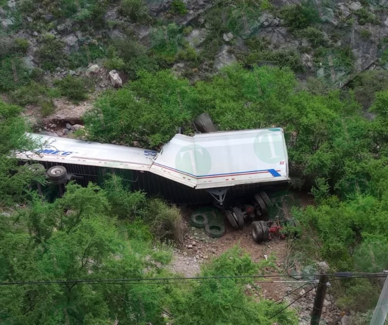 Tráiler cae de puente; socorristas tratan de ayudar al conductor.