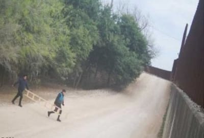 Migrantes usan escaleras para cruzar muro fronterizo en Eagle Pass.