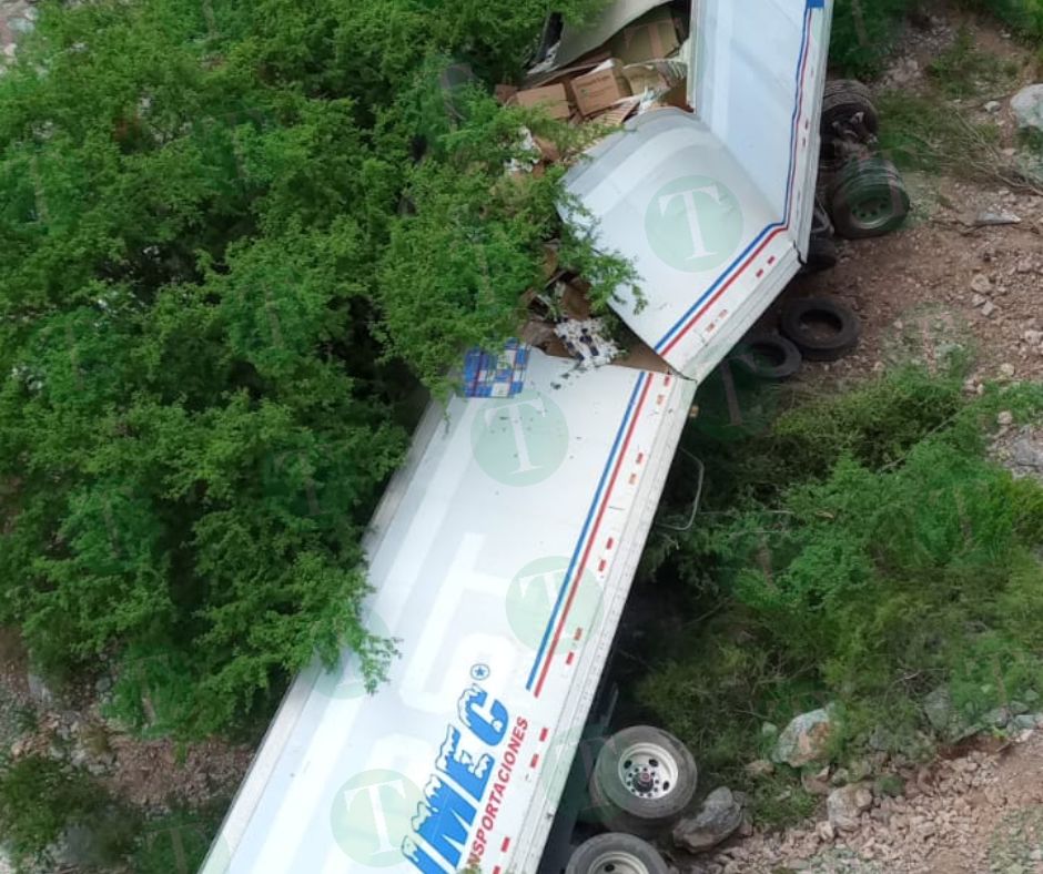 Tráiler cae de puente; socorristas tratan de ayudar al conductor.