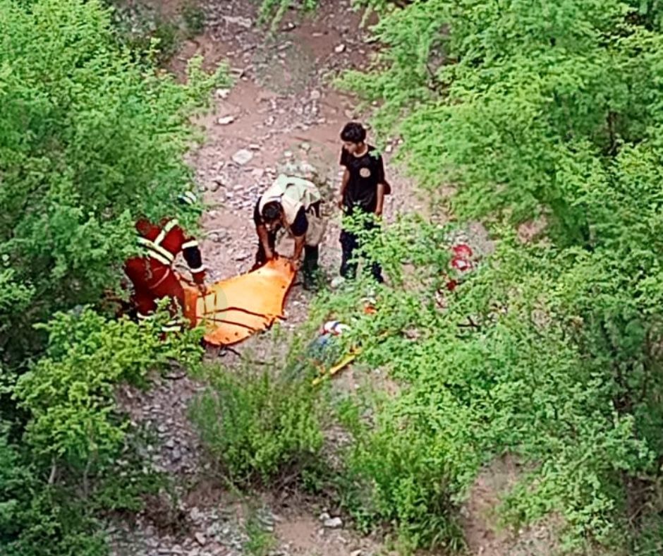 Tráiler cae de puente; socorristas tratan de ayudar al conductor.