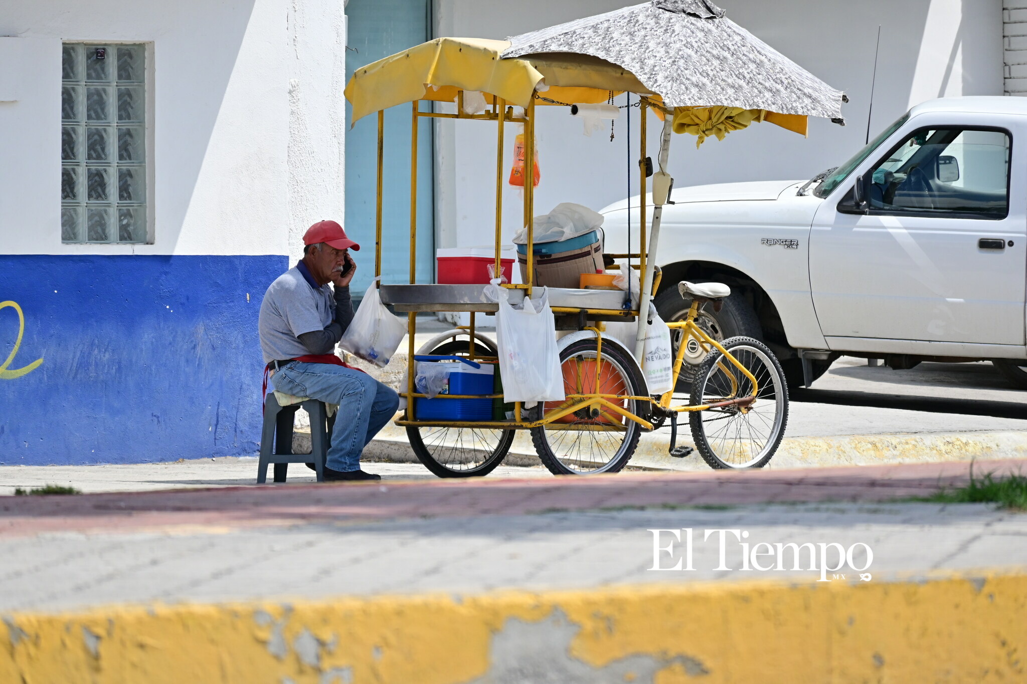 Un vendedor permanece junto a su triciclo durante su jornada de trabajo en las calles de Monclova.