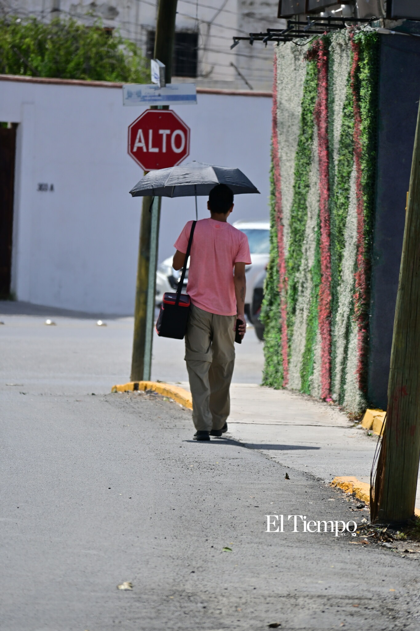 Un peatón camina por una de las calles de Monclova mientras la actividad urbana continúa a su alrededor.