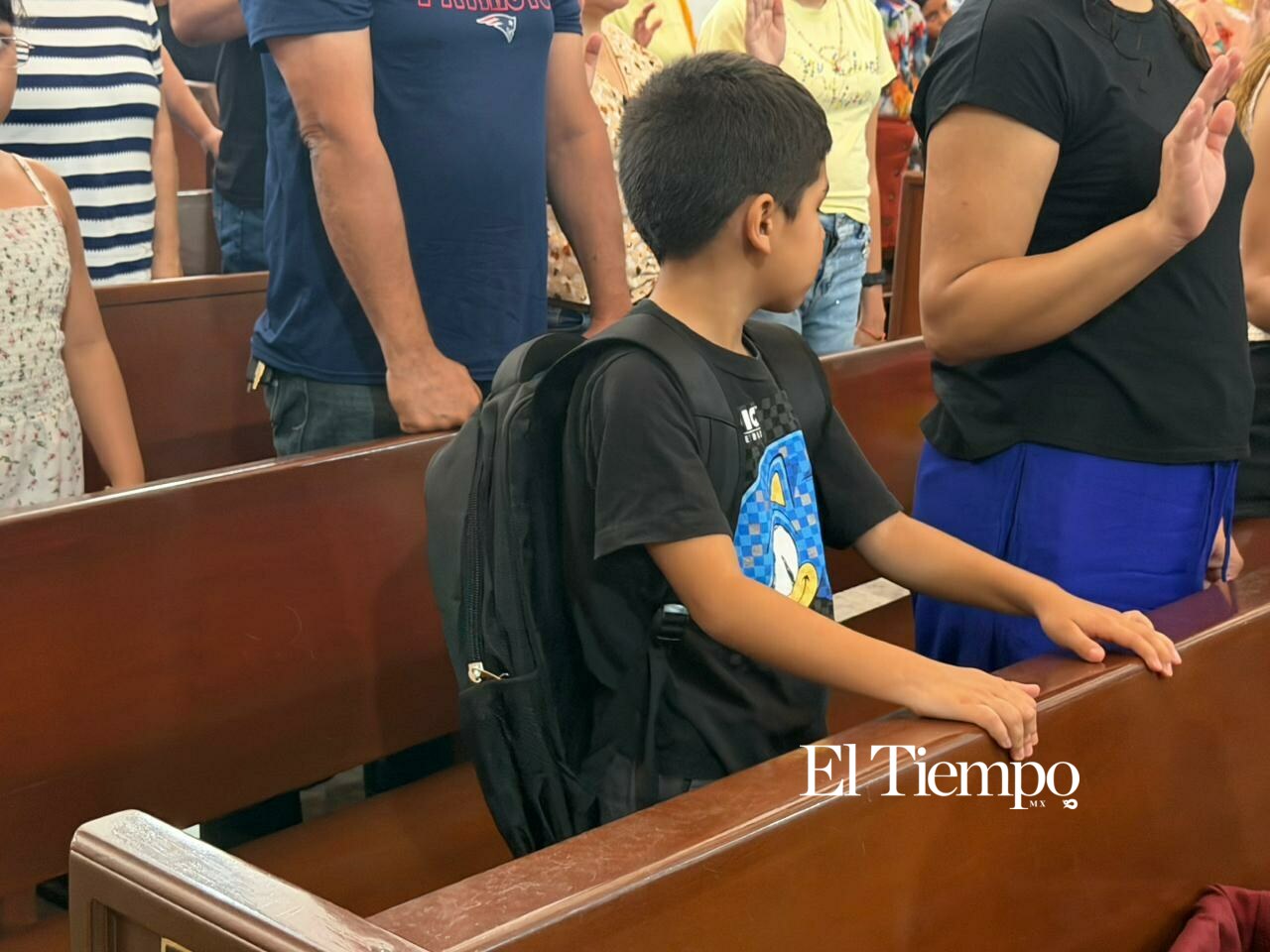 Niños llevan sus mochilas a misa para recibir bendición antes del regreso a clases