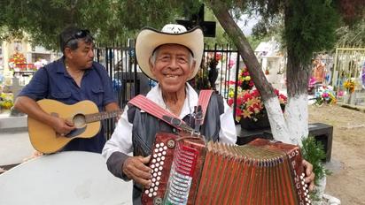 Músicos ofrecen su trabajo durante el Día de Muertos en el panteón
