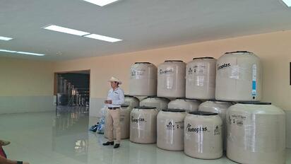 Entregan tinacos a familias de San Juan de Sabinas para enfrentar altas temperaturas y escasez de agua.