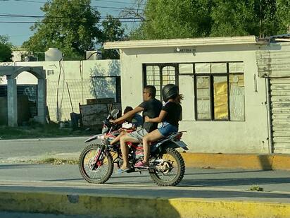 Padres arriesgan la vida de sus hijos al transportarlos sin casco en motocicletas