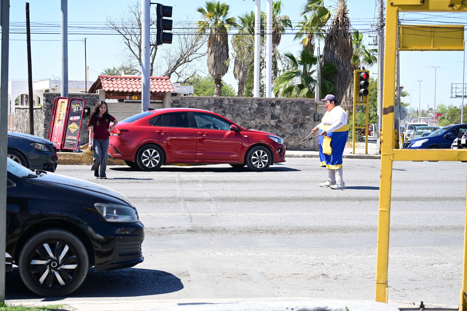 vialidad : Filas de vehículos y peatones en espera reflejan el ritmo diario del tránsito en la ciudad.