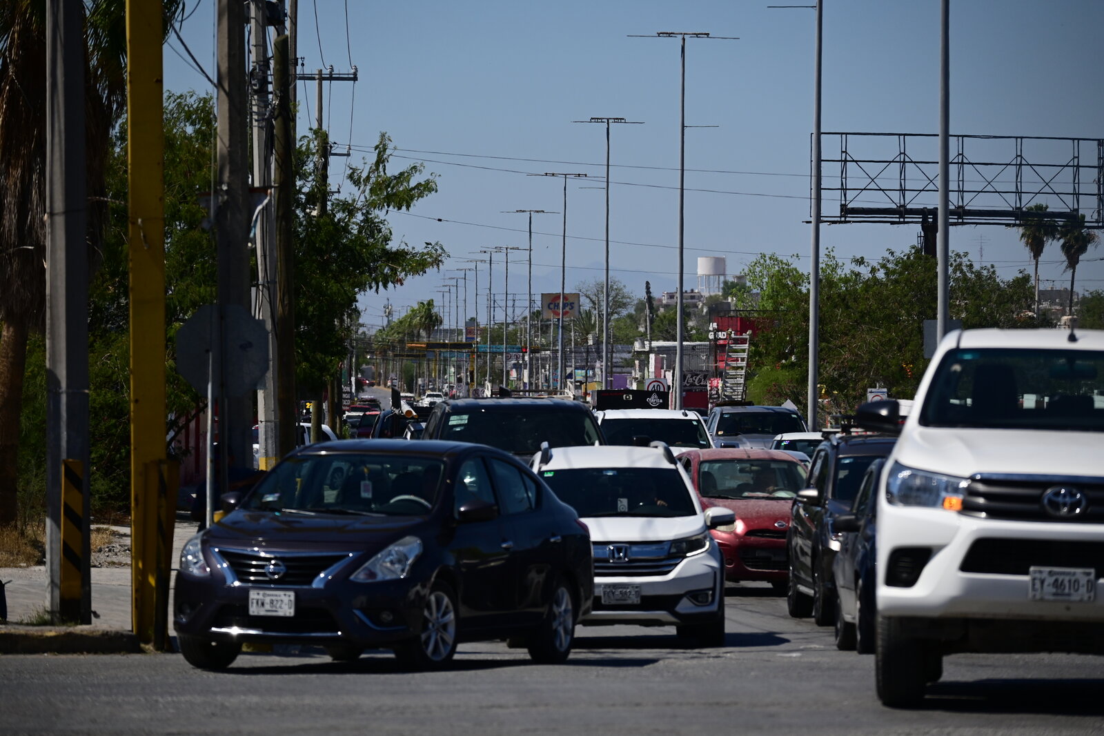 vialidad : Filas de vehículos y peatones en espera reflejan el ritmo diario del tránsito en la ciudad.